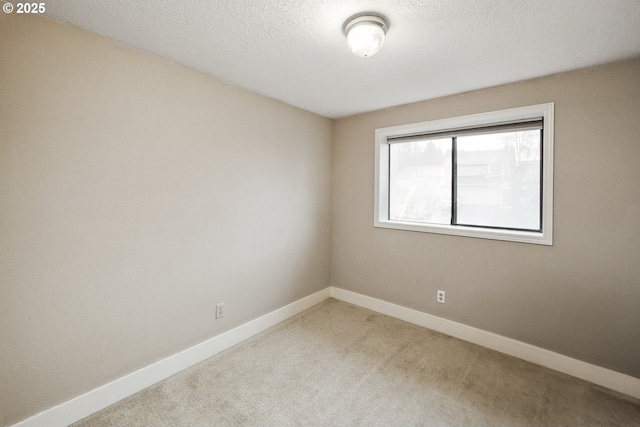 carpeted empty room with a textured ceiling