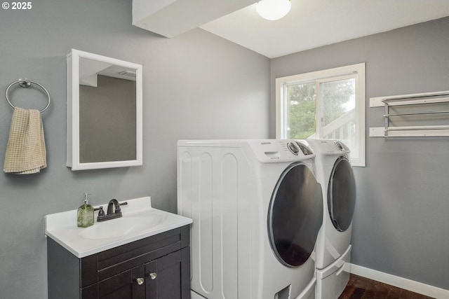 laundry room featuring sink, washer and clothes dryer, and cabinets