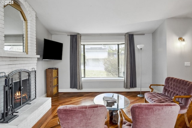 living room featuring hardwood / wood-style floors and a brick fireplace