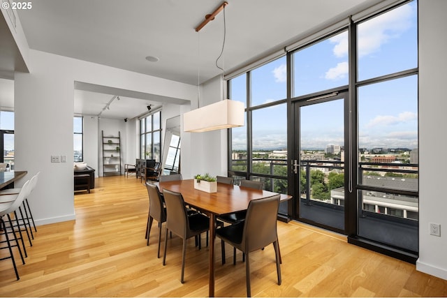 1025 NW Couch St Unit 1320, Portland, OR 97209 - dining area featuring light wood-style flooring and rail lighting