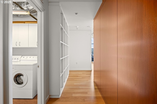 1025 NW Couch St Unit 1320, Portland, OR 97209 - laundry area featuring light wood-type flooring, washer and clothes dryer, and cabinet space