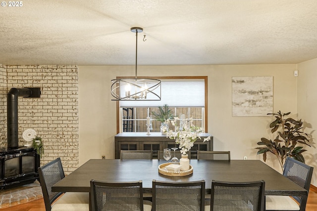 dining area with a wood stove and a textured ceiling