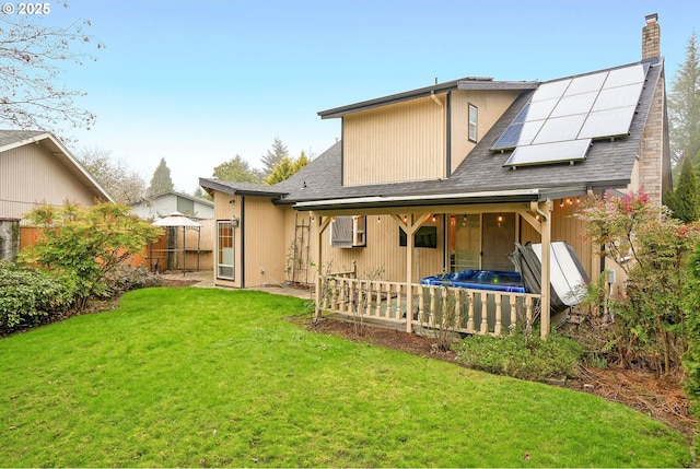 back of house featuring a lawn and solar panels