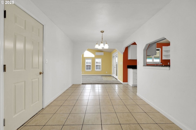 entrance foyer featuring vaulted ceiling, a notable chandelier, and light tile patterned floors