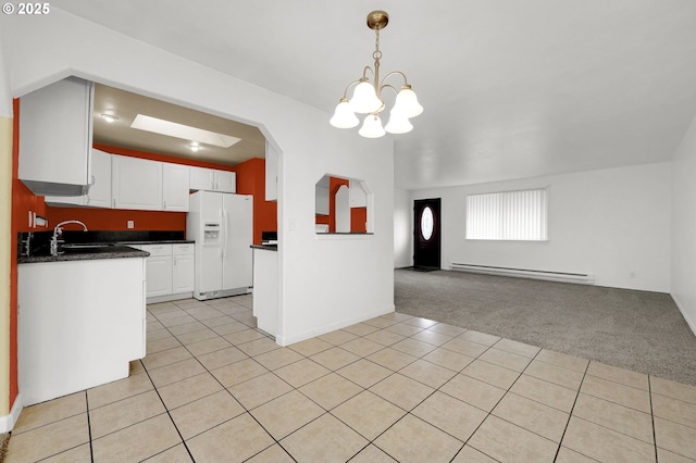 kitchen featuring white cabinetry, light carpet, a baseboard heating unit, a notable chandelier, and white fridge with ice dispenser