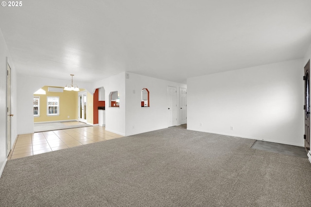 unfurnished room with a notable chandelier and light colored carpet