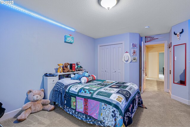 10886 SW Bretton Ct, Portland, OR 97224 - bedroom with light colored carpet, a textured ceiling, a closet, and baseboards