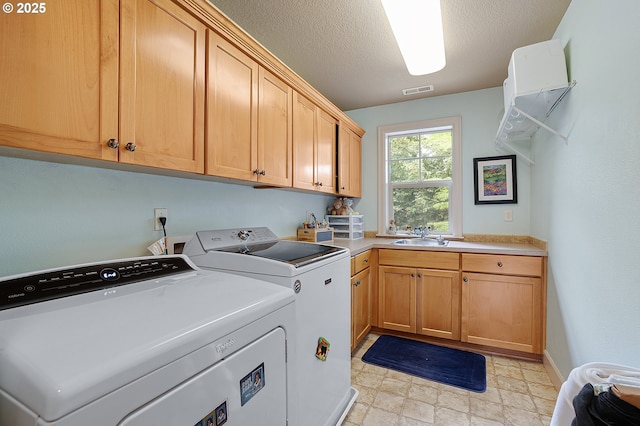 10886 SW Bretton Ct, Portland, OR 97224 - laundry room with cabinet space, washing machine and dryer, a textured ceiling, and light stone finish floors