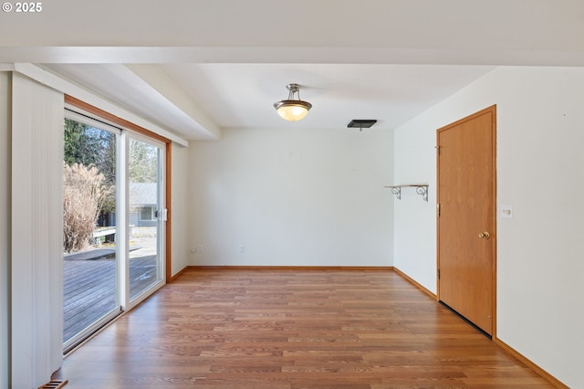 unfurnished room featuring light wood-type flooring and baseboards