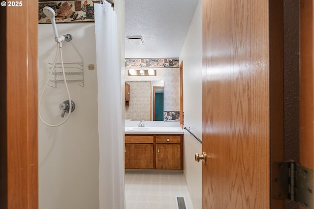 bathroom with a shower with shower curtain, visible vents, a textured ceiling, and vanity