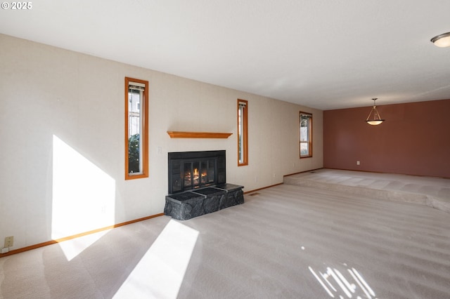 unfurnished living room with carpet flooring, baseboards, and a tiled fireplace