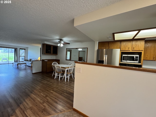13821 NW 10th Ct Unit G, Vancouver, WA 98685 - kitchen with appliances with stainless steel finishes, a textured ceiling, open floor plan, a ceiling fan, and dark wood-type flooring