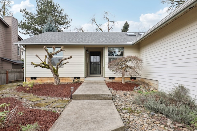 property entrance featuring crawl space, roof with shingles, and fence