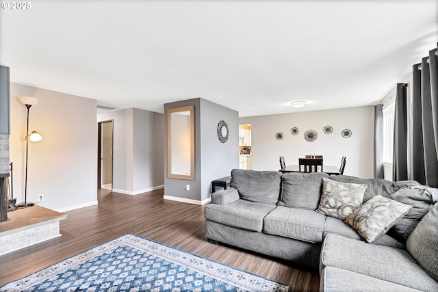 living room with a fireplace, baseboards, and dark wood-style flooring