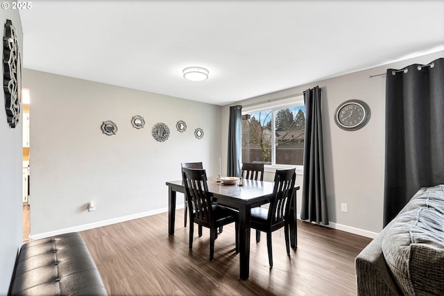 dining space featuring dark wood-style floors and baseboards