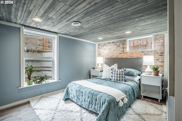 bedroom featuring wooden ceiling, light hardwood / wood-style floors, and brick wall