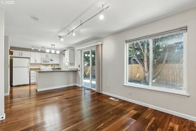 7091 SE Austin Dr, Hillsboro, OR 97123 - kitchen with white appliances, rail lighting, a peninsula, and white cabinetry