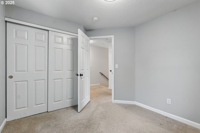 7091 SE Austin Dr, Hillsboro, OR 97123 - unfurnished bedroom featuring light carpet, a textured ceiling, and a closet