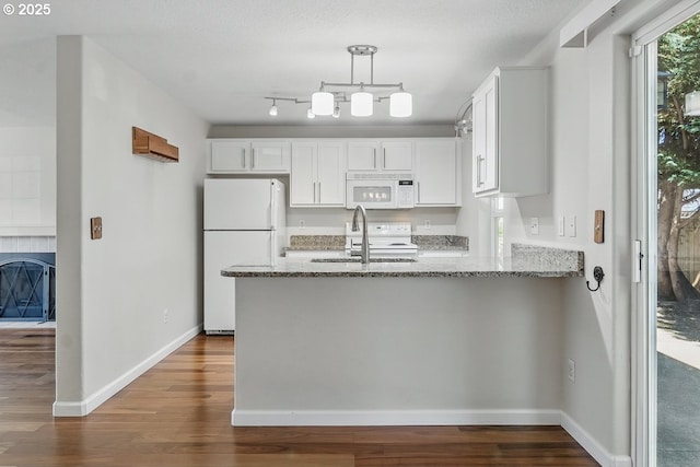 7091 SE Austin Dr, Hillsboro, OR 97123 - kitchen with white appliances, a peninsula, light stone counters, dark wood-style floors, and white cabinets