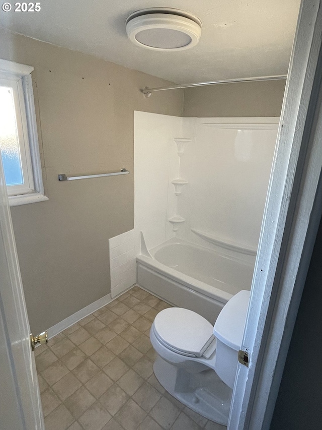 bathroom with washtub / shower combination and toilet