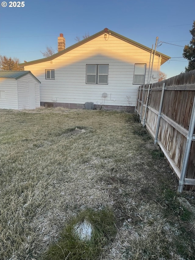 view of home's exterior with a storage shed and a yard