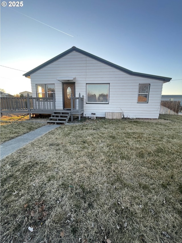 view of front of home with a yard and a deck