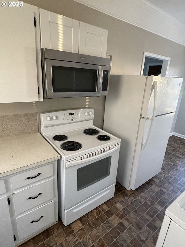 kitchen featuring white cabinetry and white appliances