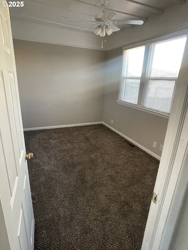 unfurnished room featuring ceiling fan and dark colored carpet