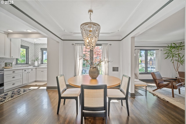 6406 N Michigan Ave, Portland, OR 97217 - dining room featuring a chandelier, wood finished floors, healthy amount of natural light, and baseboards