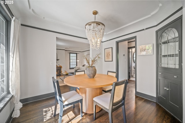 6406 N Michigan Ave, Portland, OR 97217 - dining space with dark wood-type flooring, a chandelier, baseboards, and crown molding