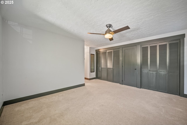 6406 N Michigan Ave, Portland, OR 97217 - unfurnished bedroom featuring carpet, baseboards, multiple closets, a textured ceiling, and a ceiling fan