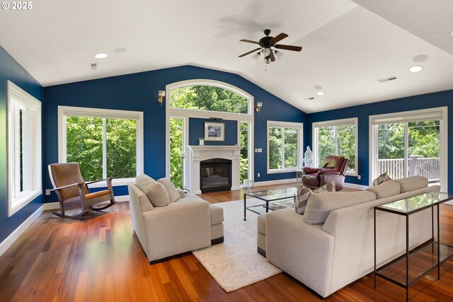 2977 Ingalls Way, Eugene, OR 97405 - living room with vaulted ceiling, a ceiling fan, a glass covered fireplace, plenty of natural light, and wood finished floors