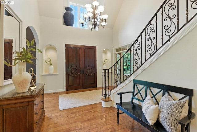 2812 Beacon Hill Dr, West Linn, OR 97068 - foyer entrance featuring high vaulted ceiling, wood finished floors, stairway, arched walkways, and a chandelier