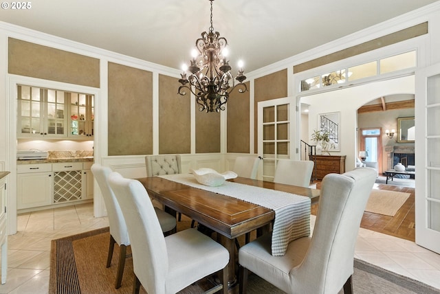 2812 Beacon Hill Dr, West Linn, OR 97068 - dining room with a chandelier, arched walkways, a decorative wall, crown molding, and a fireplace