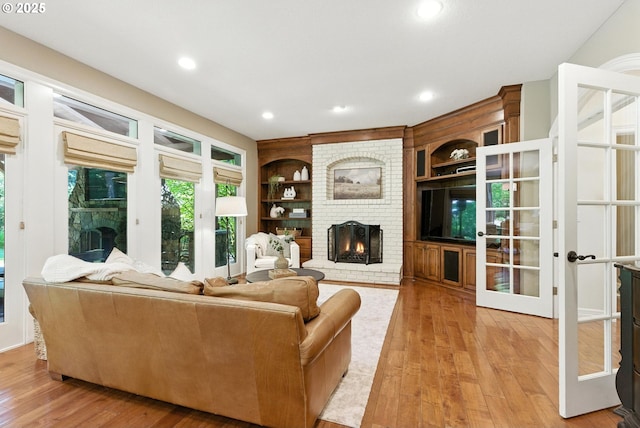 2812 Beacon Hill Dr, West Linn, OR 97068 - living room with a brick fireplace, light wood finished floors, built in shelves, and recessed lighting