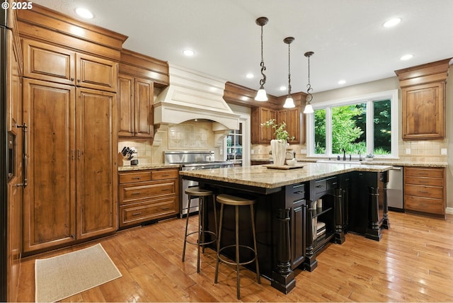 2812 Beacon Hill Dr, West Linn, OR 97068 - kitchen featuring appliances with stainless steel finishes, brown cabinetry, premium range hood, recessed lighting, and a kitchen island