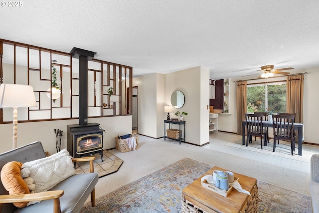 44505 SW Knight Rd, Gaston, OR 97119 - carpeted living room featuring a wood stove, a ceiling fan, a textured ceiling, and baseboards