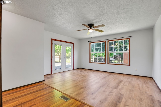 4803 SE Fieldcrest Dr, Milwaukie, OR 97222 - spare room featuring light wood-style floors, a ceiling fan, a textured ceiling, french doors, and baseboards