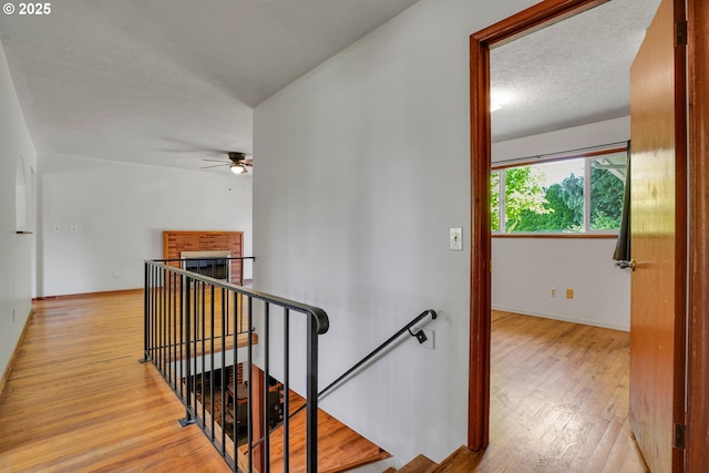 4803 SE Fieldcrest Dr, Milwaukie, OR 97222 - hallway with an upstairs landing, wood finished floors, baseboards, and a textured ceiling