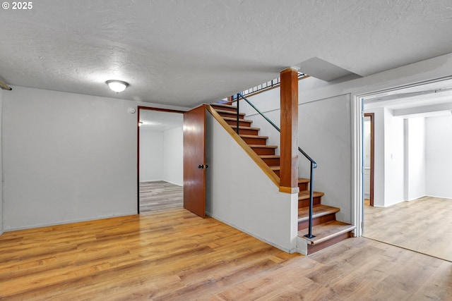 4803 SE Fieldcrest Dr, Milwaukie, OR 97222 - finished basement featuring a textured ceiling, wood finished floors, and stairs