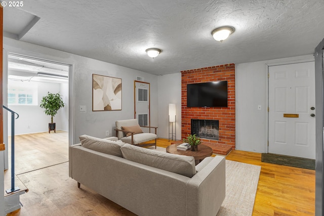 4803 SE Fieldcrest Dr, Milwaukie, OR 97222 - living area featuring light wood-style floors, a fireplace, and a textured ceiling