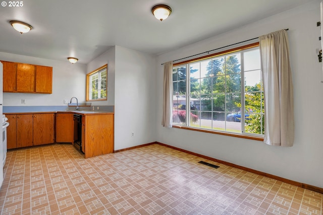 4803 SE Fieldcrest Dr, Milwaukie, OR 97222 - kitchen with baseboards, plenty of natural light, light countertops, and brown cabinets