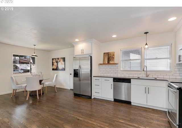 2747 NE Bryant St, Portland, OR 97211 - kitchen with stainless steel appliances, a sink, dark countertops, decorative backsplash, and dark wood-type flooring
