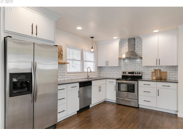 2747 NE Bryant St, Portland, OR 97211 - kitchen with stainless steel appliances, wall chimney range hood, a sink, dark countertops, and recessed lighting