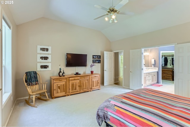 bedroom with connected bathroom, light colored carpet, baseboards, lofted ceiling, and a closet