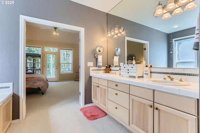 ensuite bathroom with double vanity, baseboards, a sink, and ensuite bathroom