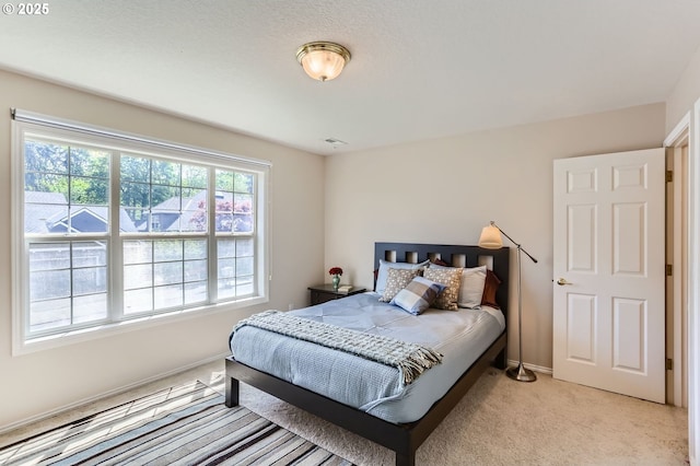 bedroom with baseboards, light colored carpet, and visible vents