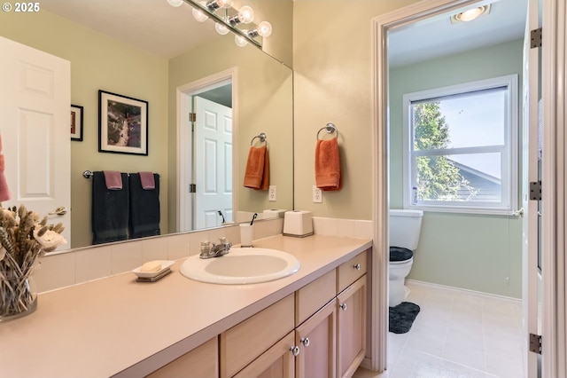 bathroom featuring toilet, baseboards, and vanity