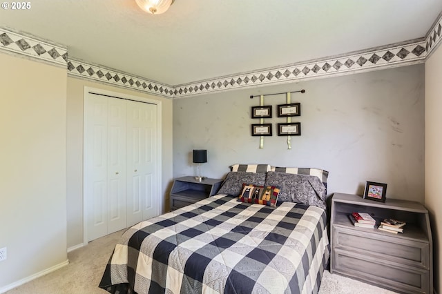 carpeted bedroom featuring baseboards and a closet