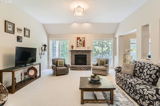 carpeted living area with lofted ceiling, a healthy amount of sunlight, and a fireplace